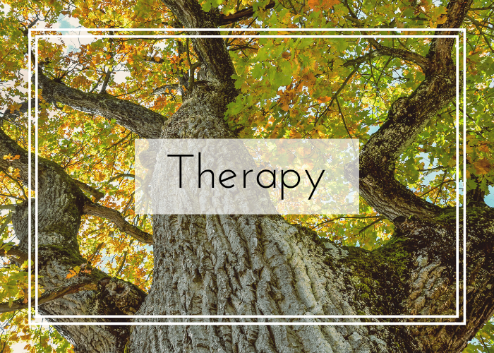 Therapy Button with picture in background looking up a tree with green and yellow leaves